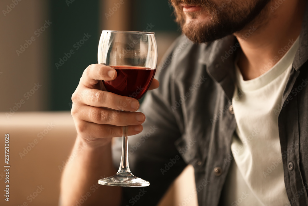 Man drinking wine at home, closeup