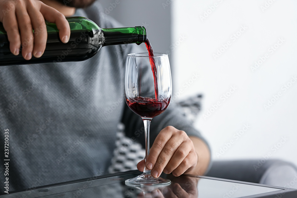 Man pouring wine into glass, closeup