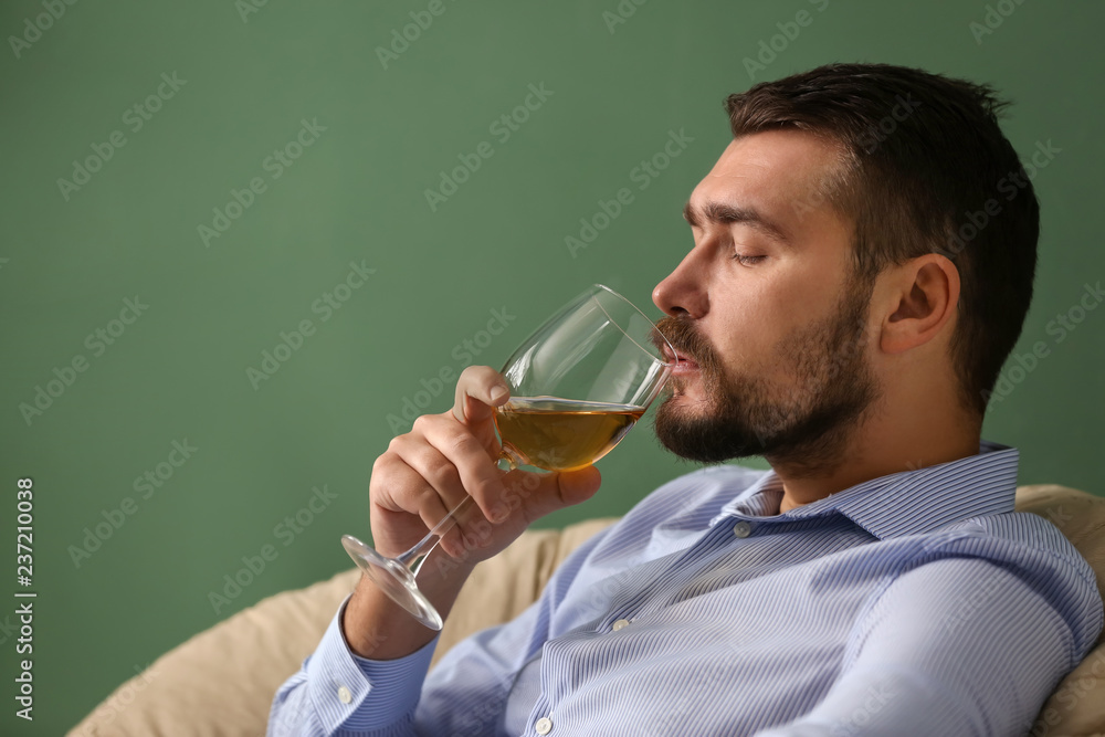 Man with glass of wine relaxing at home