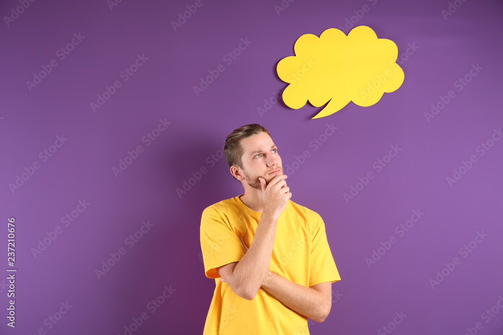 Thoughtful young man and blank speech bubble on color background