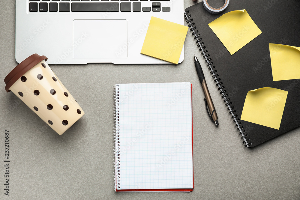 Laptop, notebook and plastic coffee cup on table, top view