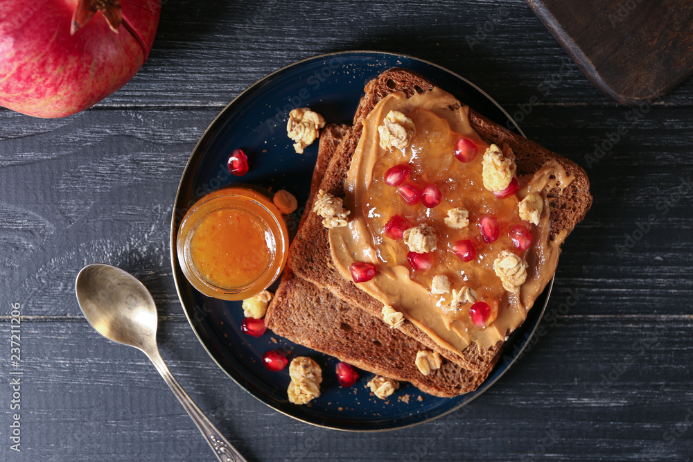 Plate with sweet toasts and jam on wooden table