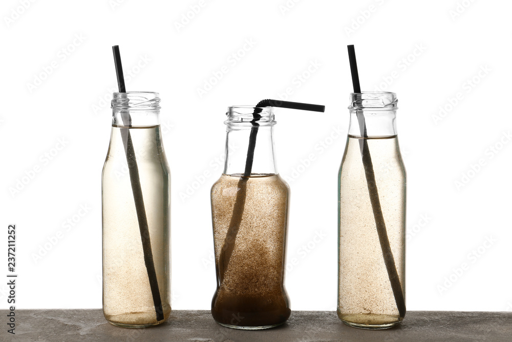 Bottles of dirty water on white background