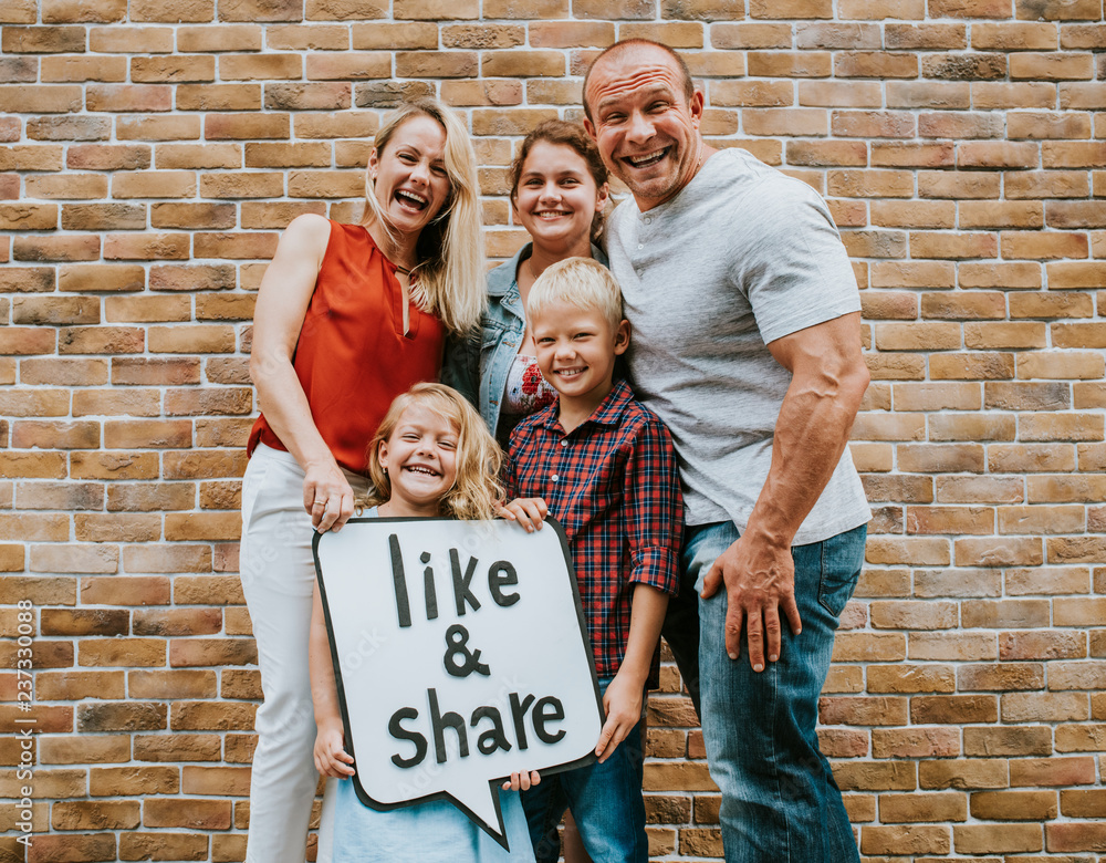 Family holding a like and share sign