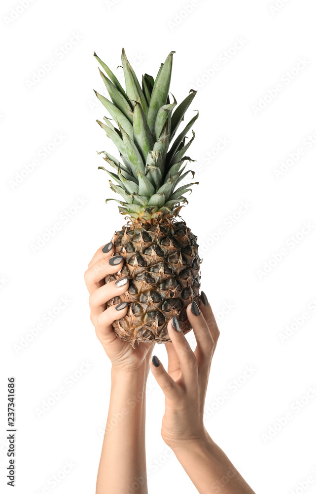 Female hands with manicure holding pineapple on white background