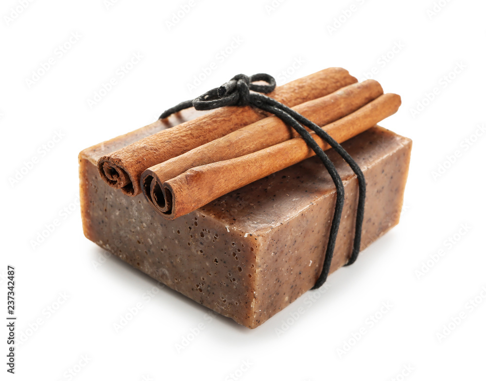 Soap bar with cinnamon sticks on white background