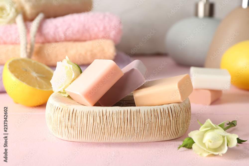 Different soap bars with roses on color wooden table