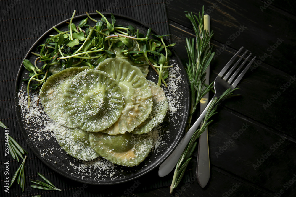 Plate with tasty ravioli on table, top view