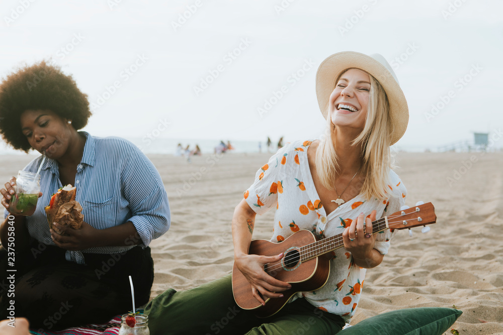 Friends singing together at a beach picnic