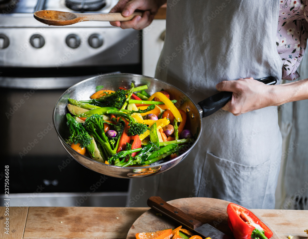 Woman cooking stir fried vegetables