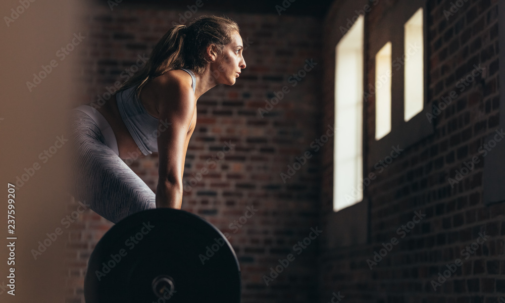 Athlete doing weight lifting exercise in gym