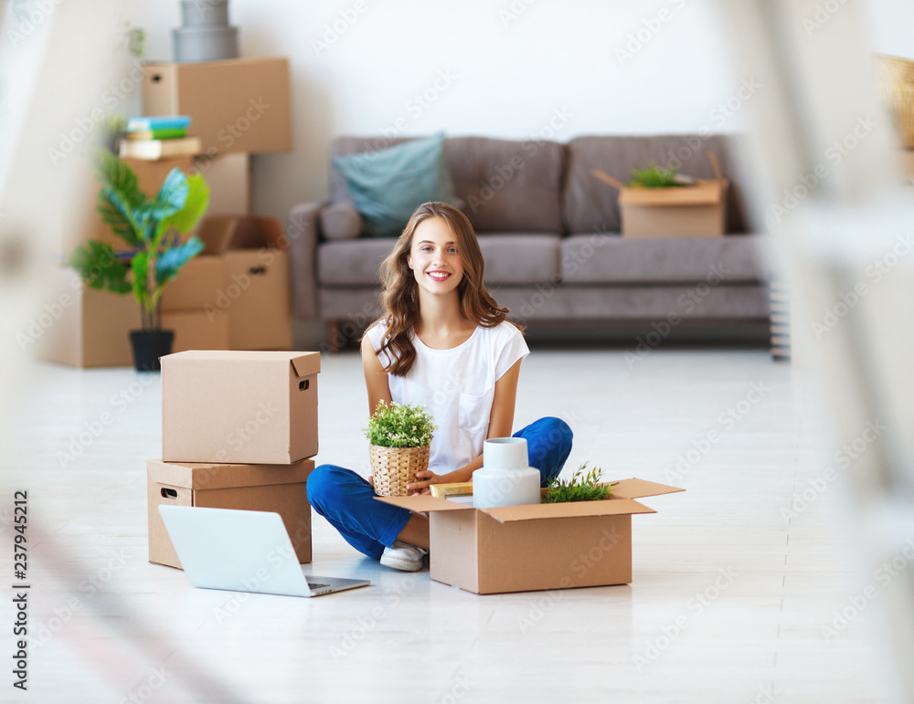 happy   girl with boxes moves to new apartment