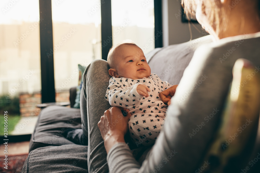 Woman sitting on couch with her baby