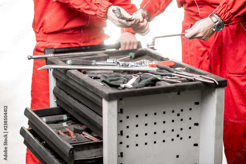 Workers taking wrenches from the working table at the car service, close-up view