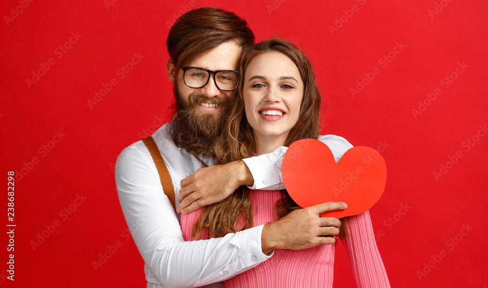 valentines day concept. happy young couple with heart, flowers, gift on red