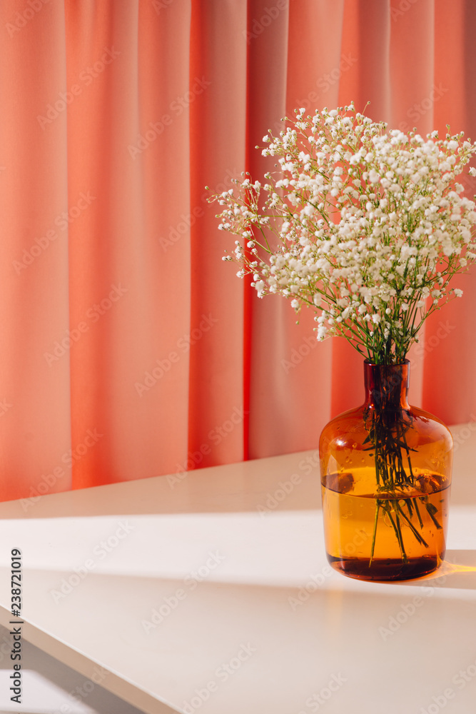 Gypsophila (Babys breath flowers), in glass bottle on textured background. Beautiful light, airy ma