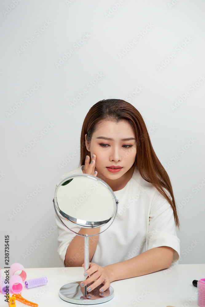 Young asian woman looking a mirror.