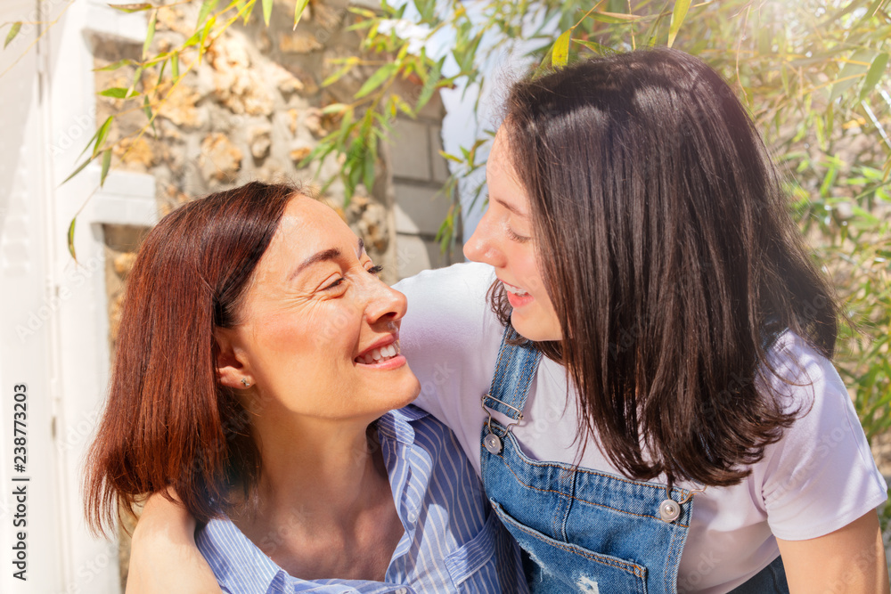 Happy teenage girl hugging her mother