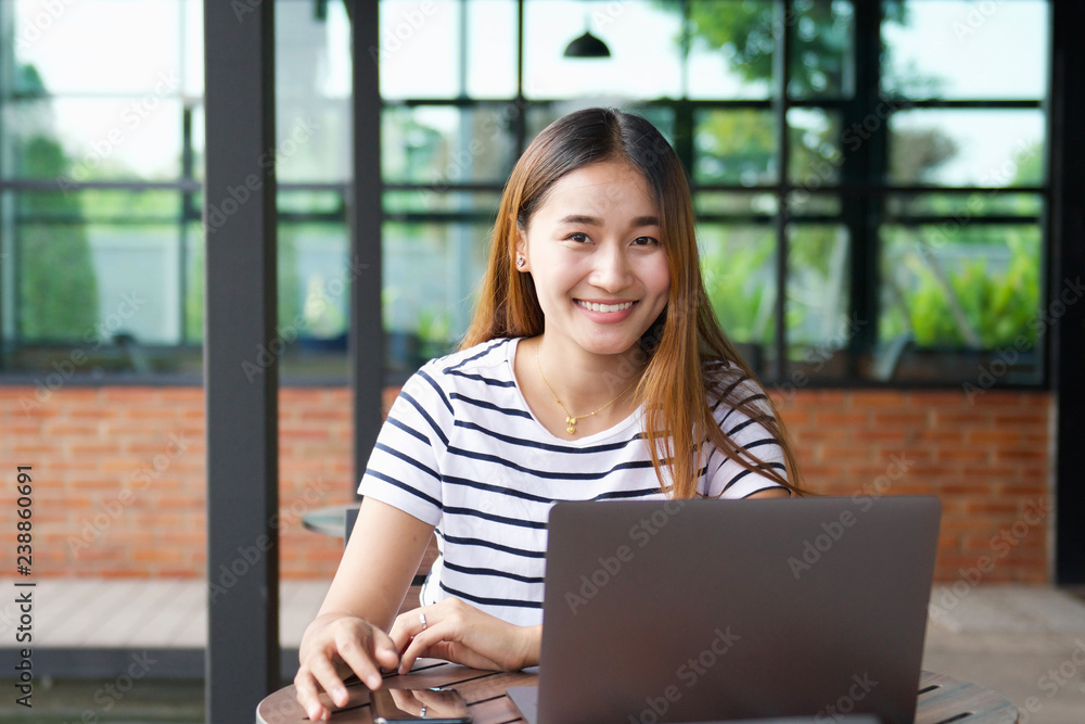 happy woman using laptop for working at cafe