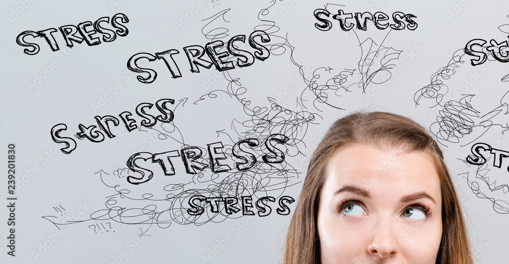 Stress theme with young woman looking upwards on a gray background