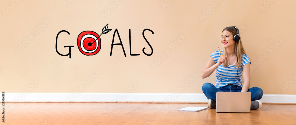 Goals with target with young woman with headphones using a laptop computer and a pencil