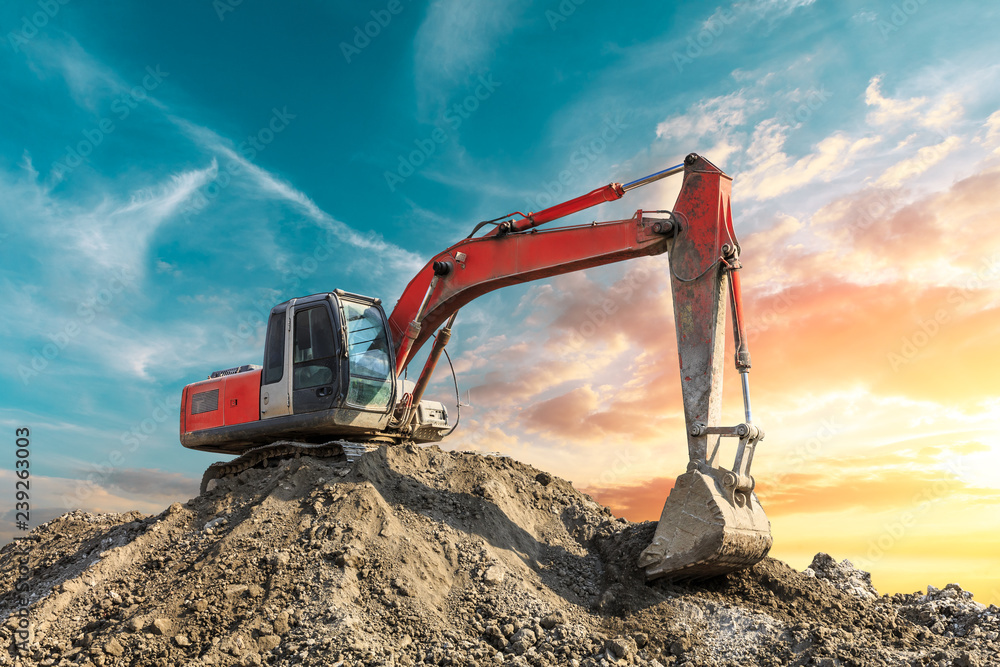 Excavator work on construction site at sunset