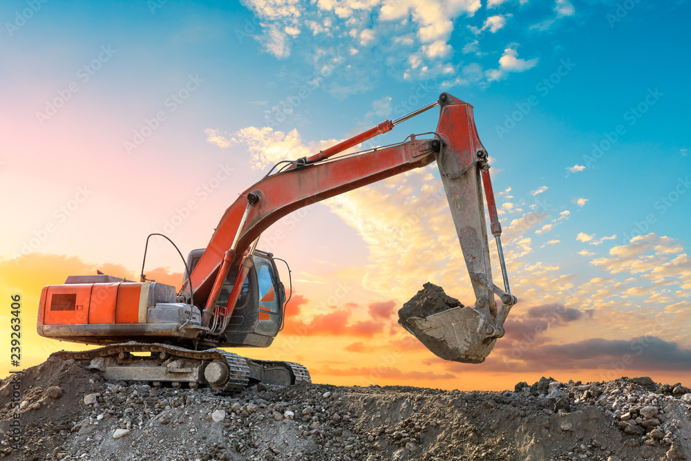 Excavator work on construction site at sunset