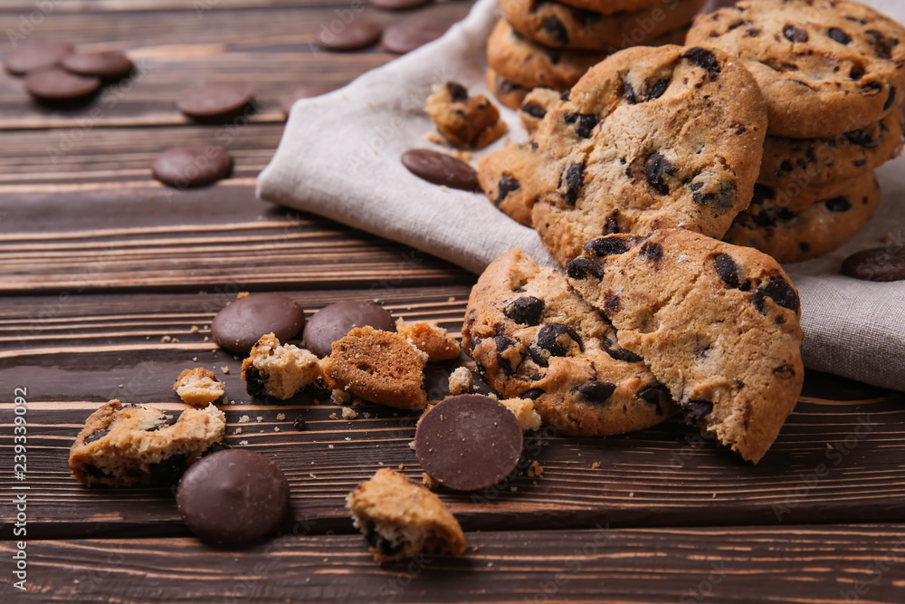 Tasty cookies with chocolate chips on wooden table