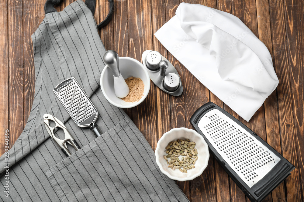 Chefs hat with  kitchenware on wooden table