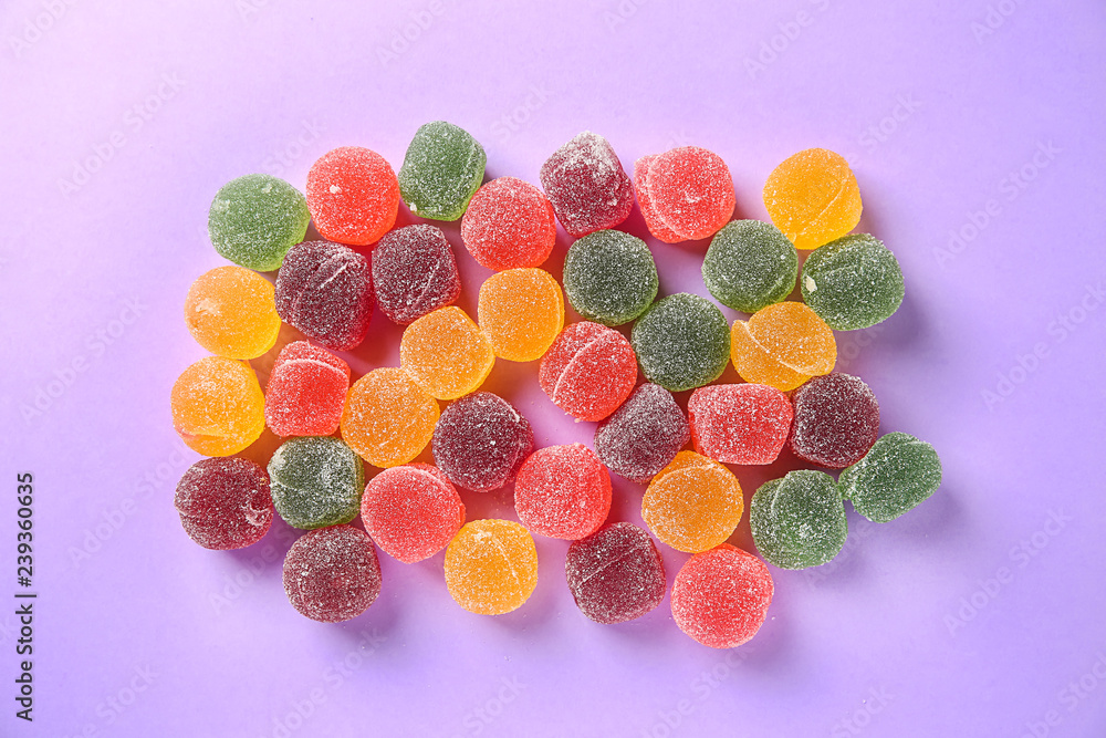 Tasty sweet candies on color background