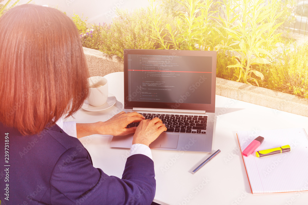 Woman working with laptop computer at street cafe