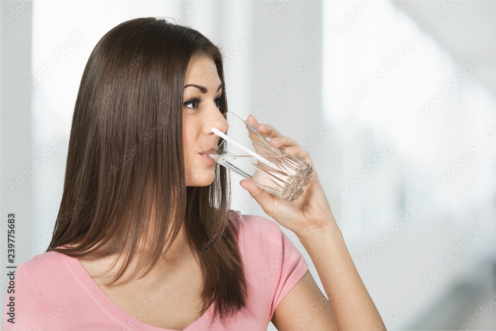 Happy young woman drinking water isolated on white