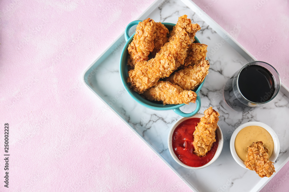 托盘上有酱汁和一杯饮料的美味金块