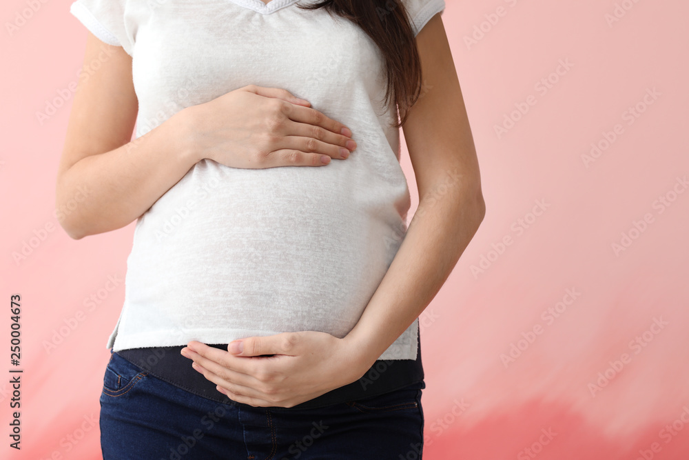 Beautiful pregnant woman on color background, closeup