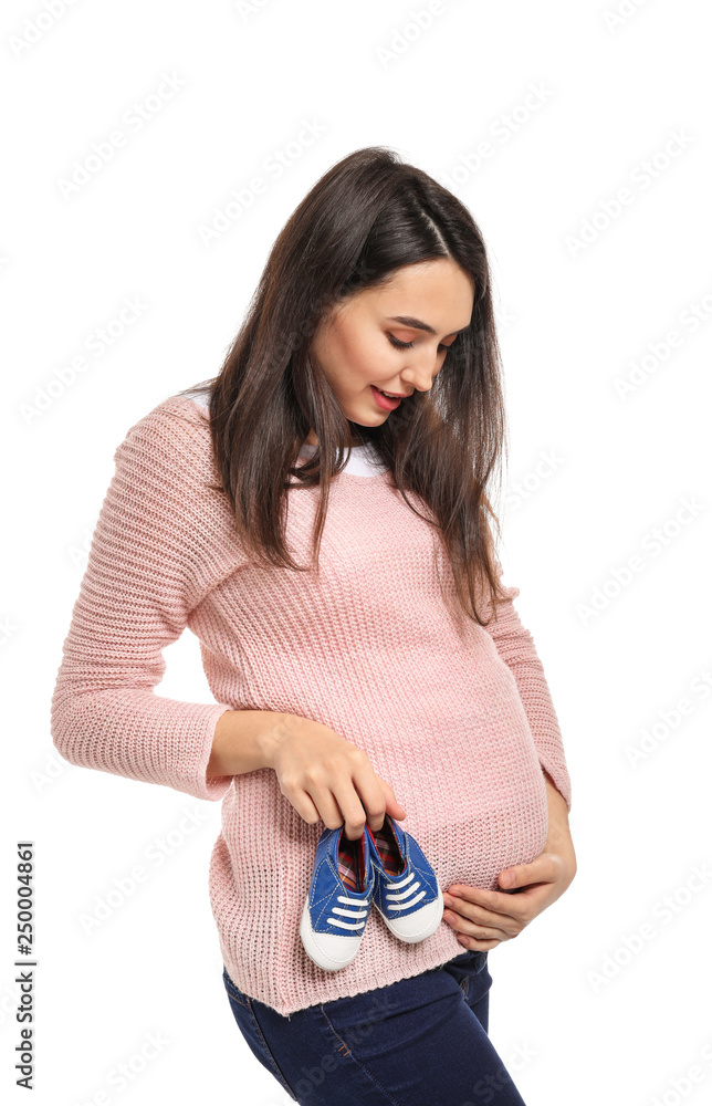 Portrait of beautiful pregnant woman with baby booties on white background