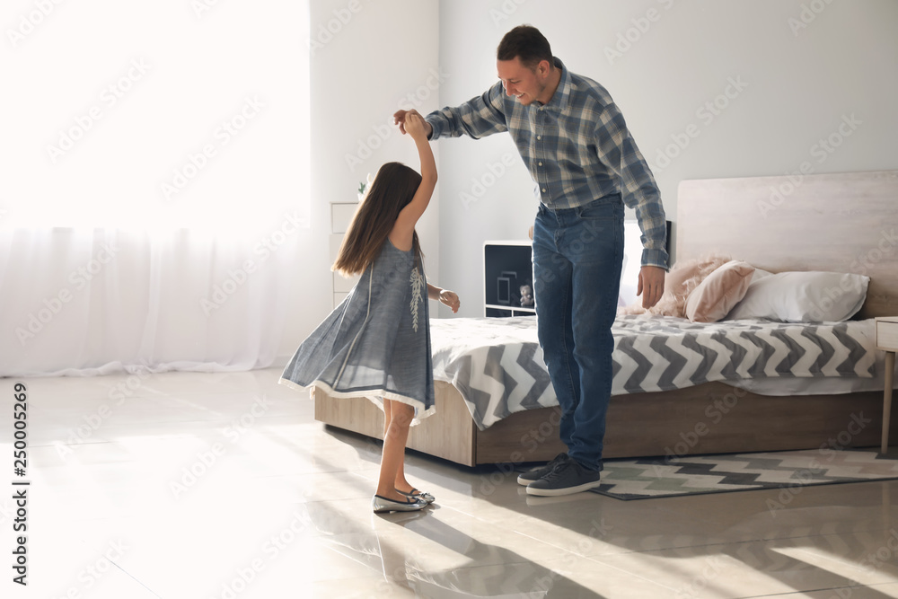 Father and his cute little daughter dancing at home