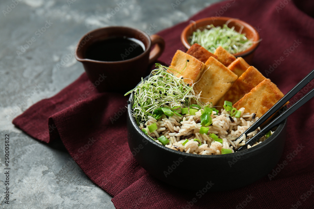 灰色桌子上碗里的美味米饭配豆腐奶酪