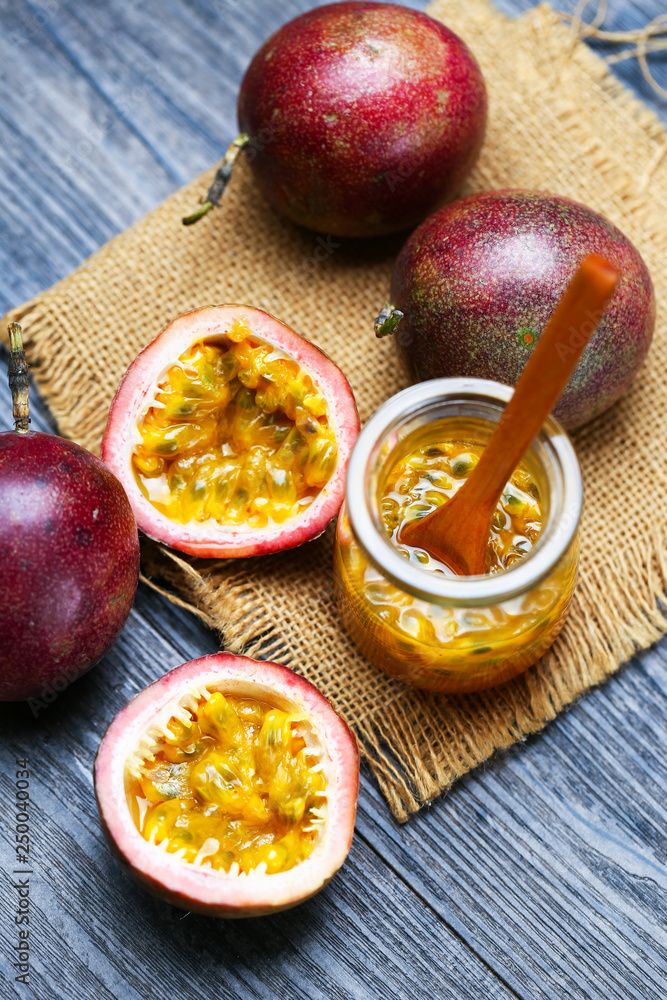 fresh passion fruit juice in glass bottle wooden spoon on dark wooden table