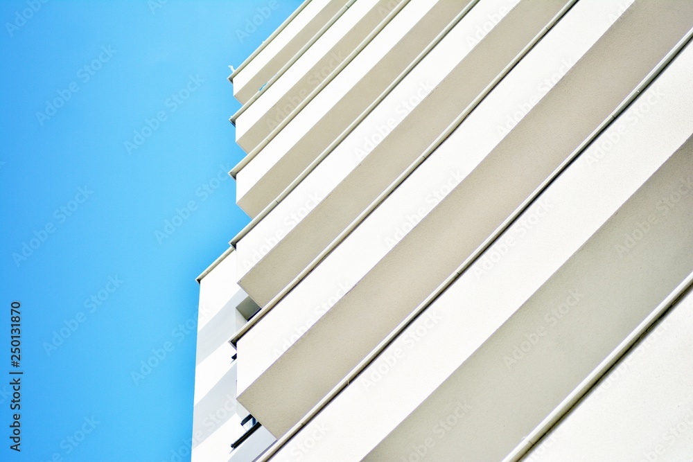 Modern white building with balcony on a blue sky