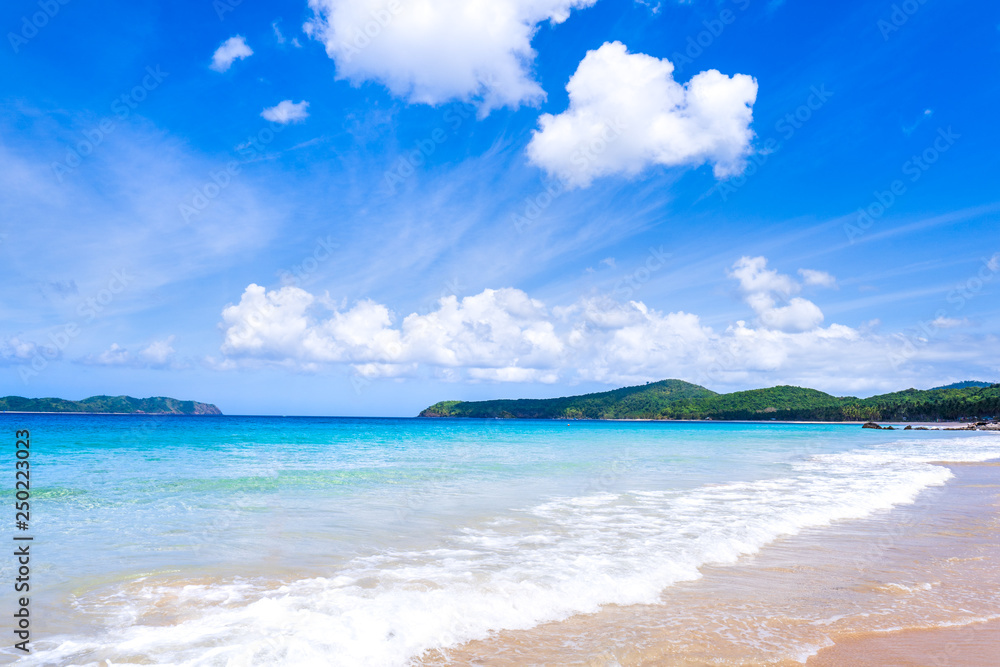 Beautiful amazing gold colored sandy beach with soft waves isolated with sunny blue sky. Concept of 