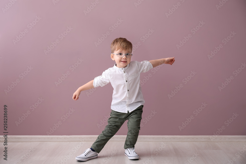 Portrait of cute little boy near color wall