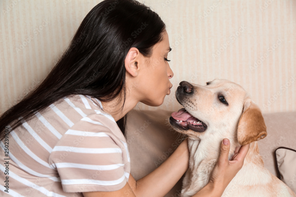 家里年轻女子和她可爱的拉布拉多犬的肖像