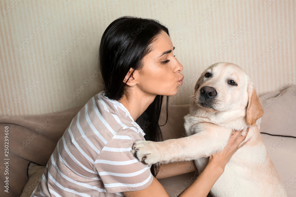 家里年轻女子和她可爱的拉布拉多犬的肖像