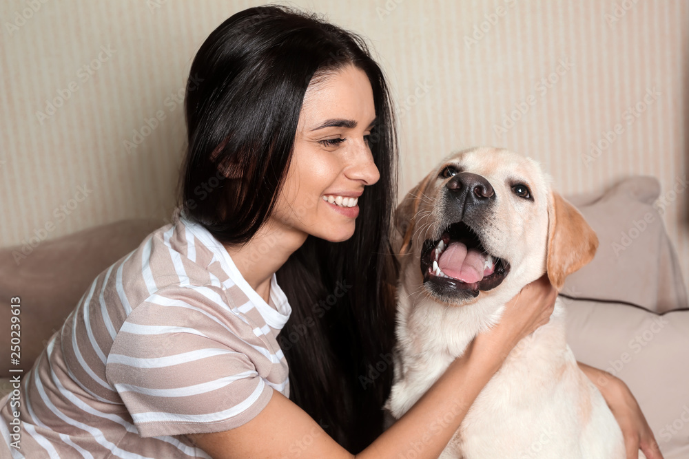 家里年轻女子和她可爱的拉布拉多犬的肖像