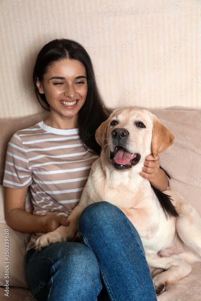 家里年轻女子和她可爱的拉布拉多犬的肖像