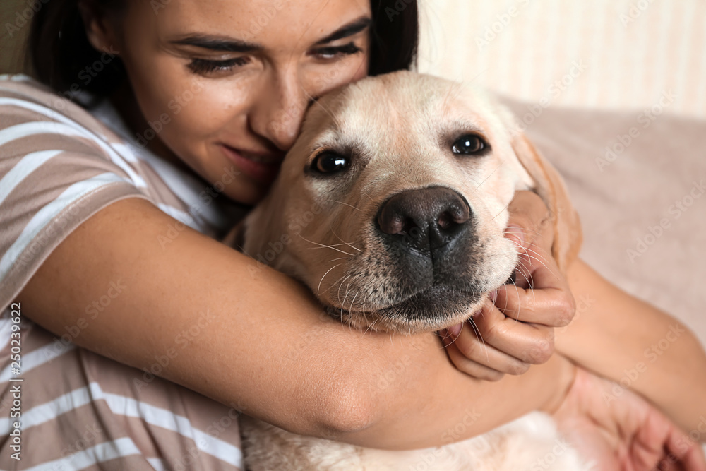 一位年轻女子和她可爱的拉布拉多犬在家的肖像