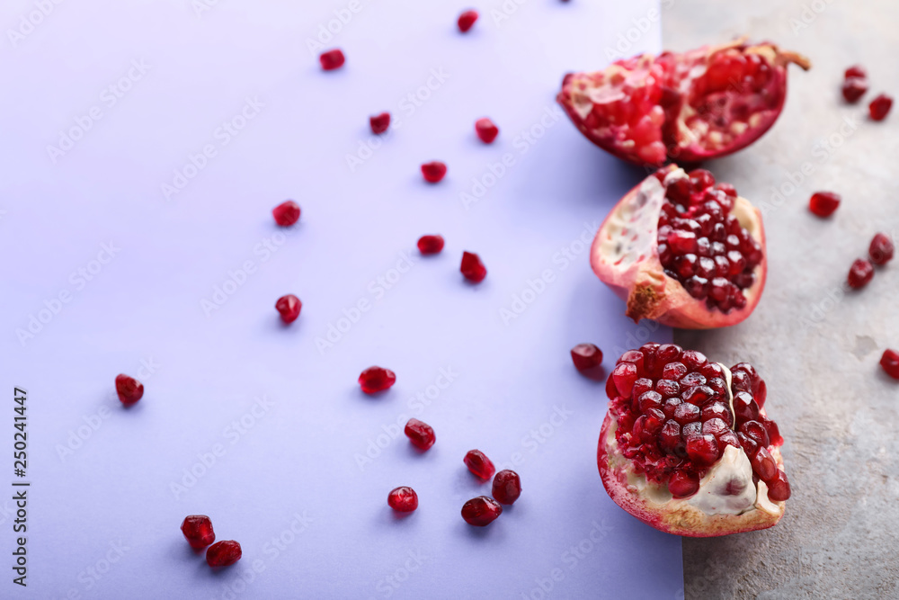 Pieces of ripe pomegranate on color background