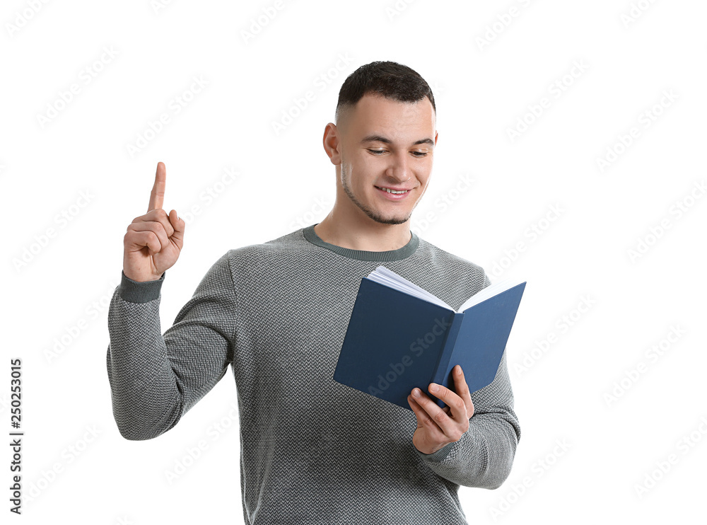 Handsome young man with book and raised index finger on white background