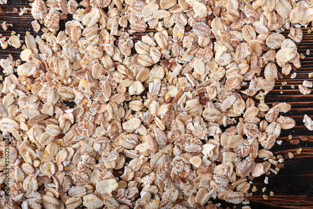 Heap of oat flakes on wooden background, closeup