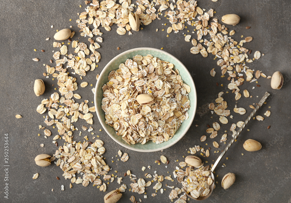 Bowl with oat flakes on grey background